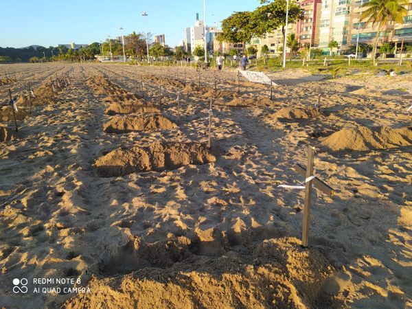 Cruzes e faixa colocadas na areia da Praia de Camburi neste domingo (21) fazem menção a mortos pelo novo coronavírus no ES