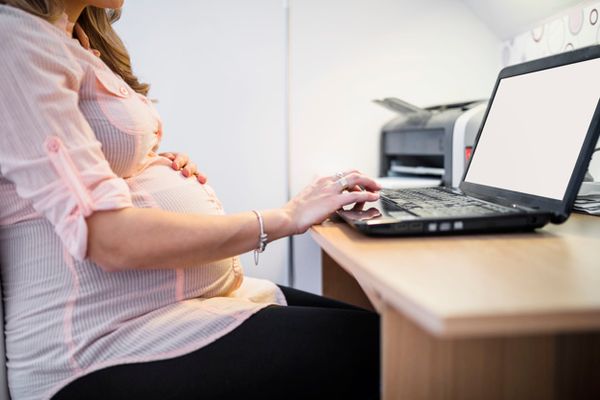 Mulher grávida usando computador