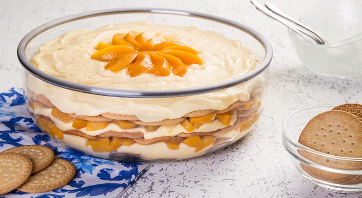 Bastante simples e rápido de preparar, o doce contém biscoitos, pedaços de pêssego em calda, coco ralado e creme à base de leite e gemas