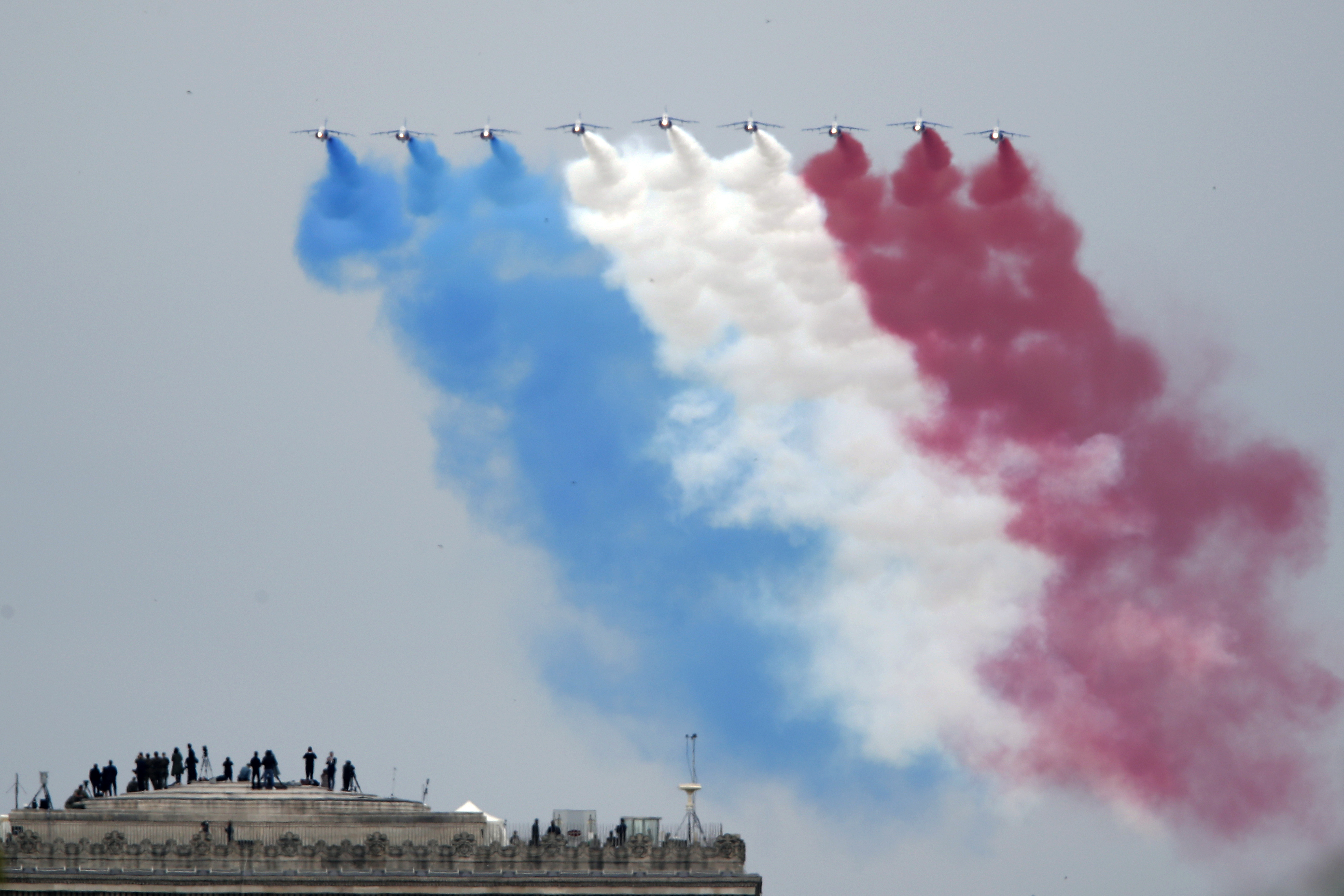 Aeronaves da Patrouille de France, o esquadrão de demonstração e acrobacia aérea da Força Aérea Francesa, sobrevoam o topo do Arco do Triunfo, em Paris, na França,   durante a celebração do Dia da Bastilha