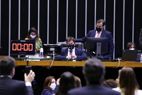 Felipe Rigoni, sentado na cadeira de presidente da Câmara, auxiliado pelo atual presidente da Casa, Rodrigo Maia