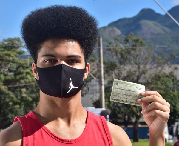 Celso de Almeida Bezerra Junior, Morador de Colina de Laranjeiras na Serra, foi fotografada na rua do seu bairro, com o título de eleitor em mãos