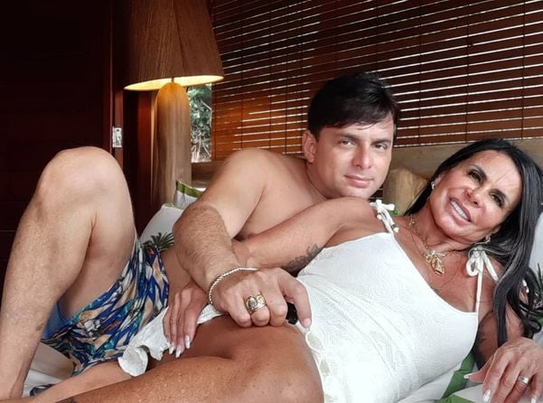 O saxofonista Esdras de Souza e a noiva, a artista Gretchen, deitados em uma cama trocando carícias