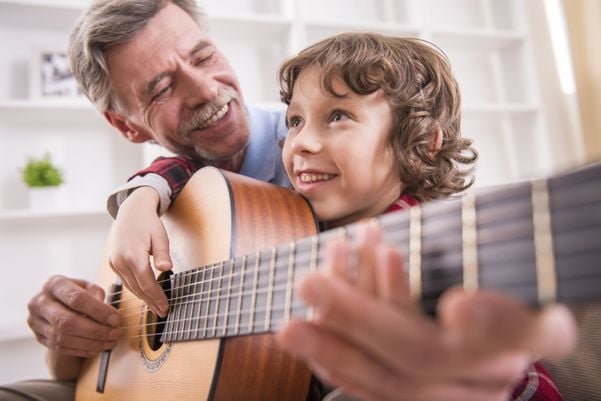 Pai mais velho tocando violão com o filho