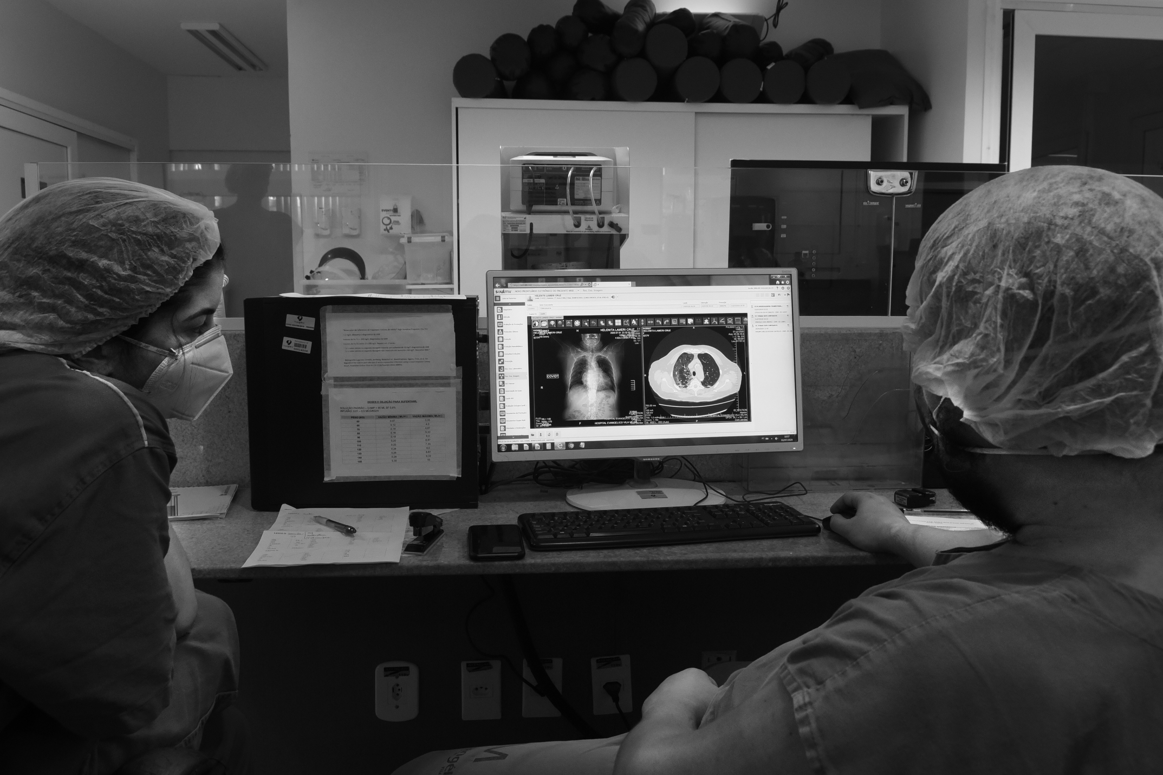 Médicos observam os exames de pulmão de uma paciente grave com covid-19