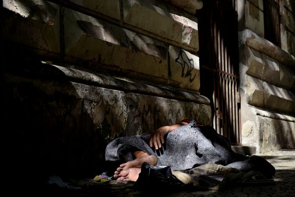 Homem em situação de rua dorme na calçada do antigo prédio do Arquivo Público, na Cidade Alta, em Vitória.