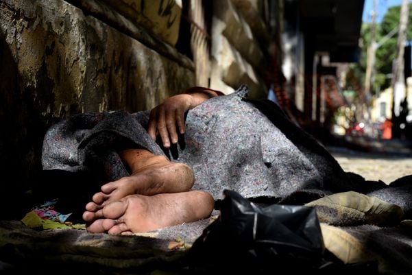 Homem em situação de rua dorme na calçada do antigo prédio do Arquivo Público, na Cidade Alta, em Vitória.