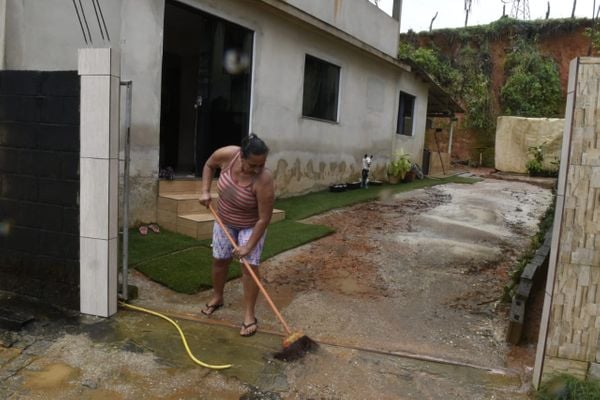 A dona de casa Maria Aparecida Gabriel limpa a casa após enchente causada pela chuva