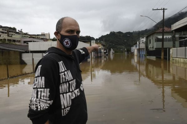 O comerciante Carlos Donatelli mostra rua alagada em Iconha
