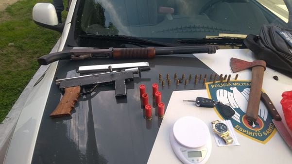 A imagem mostra as armas e munições apreendidas dispostas em cima do capô de uma viatura da Polícia Militar