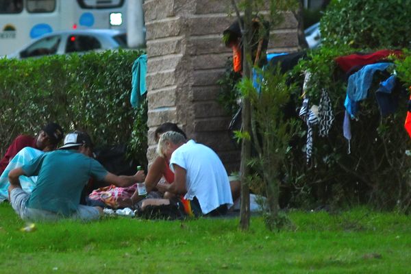 Grupo de pessoas em situação de rua se aglomeram e compartilham bebida ao lado de monumento na Praça do Papa por Fernando Madeira
