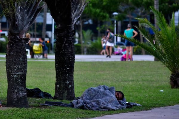 Homem em situação de rua dorme na grama da Praça do Papa por Fernando Madeira