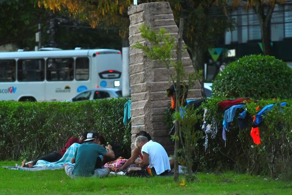 Grupo de pessoas em situação de rua se aglomeram ao lado de monumento na Praça do Papa por Fernando Madeira