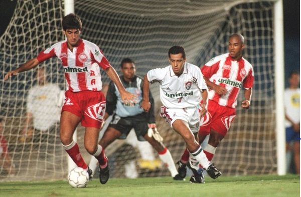 Zagueiro Didinho (com a bola) e Edinho atrás do tricolor Marco Brito. Registro do jogo de volta