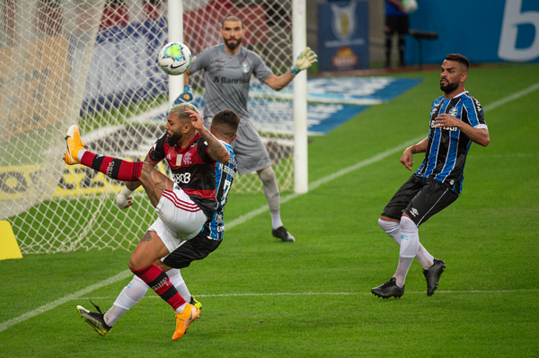 A imagem mostra o atacante flamenguista Gabriel Barbosa tentando um passe dentro da área do Grêmio