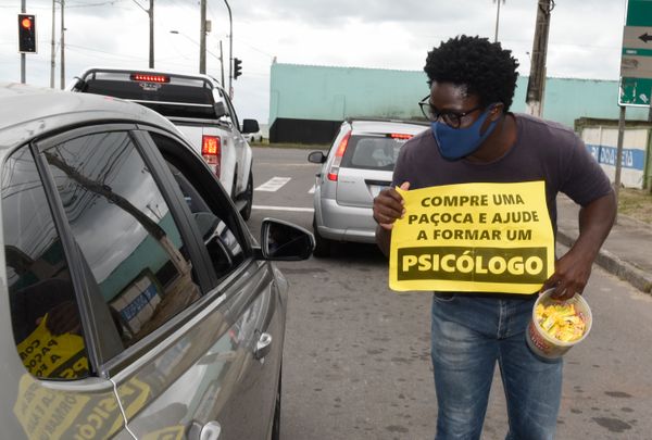 O estudante de Psicologia Landerson Freitas Queiroz da Silva vende paçoca em um semáforo de Vila Velha para conseguir pagar a mensalidade da faculdade.