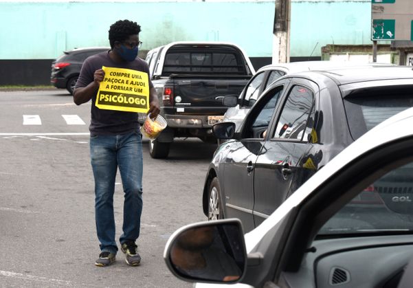 O estudante de Psicologia Landerson Freitas Queiroz da Silva vende paçoca em um semáforo de Vila Velha para conseguir pagar a mensalidade da faculdade.