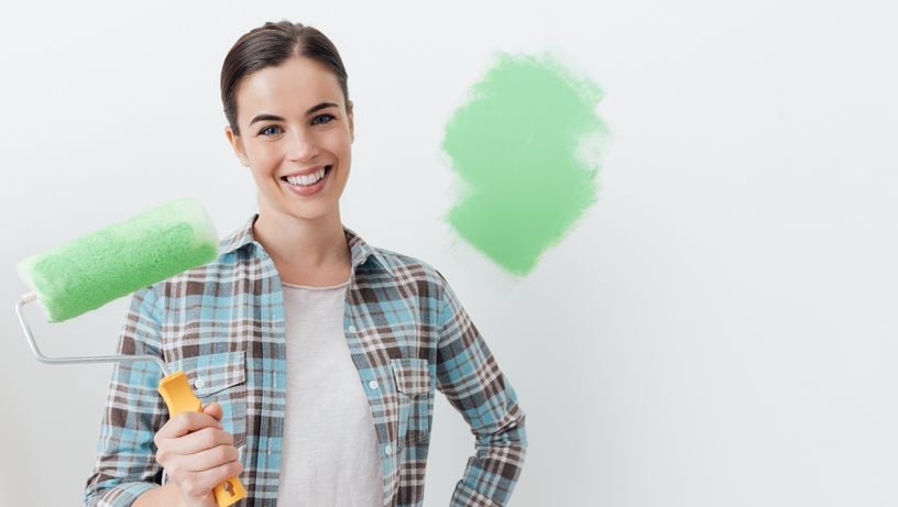 Mulher segurando o rolo de pintura de parede
