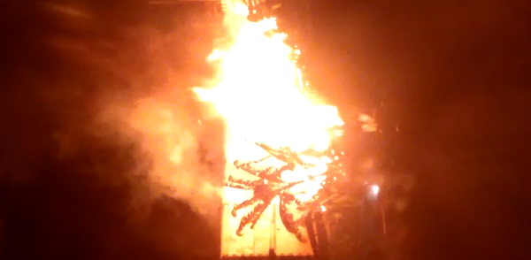 A imagem mostra o fogo destruindo a casa de madeira