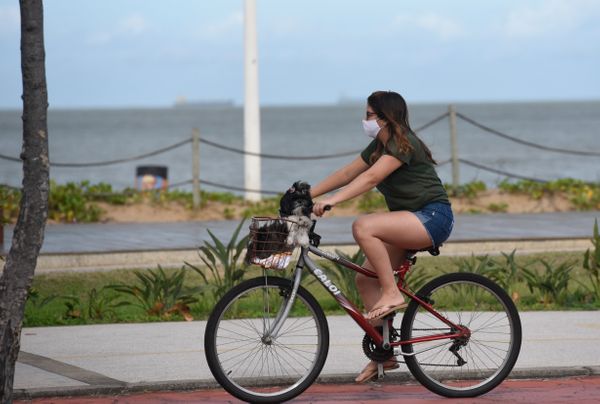 Ciclista com máscara no calçadão de Camburi
