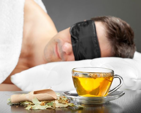 Homem dormindo com xícara de chá ao lado