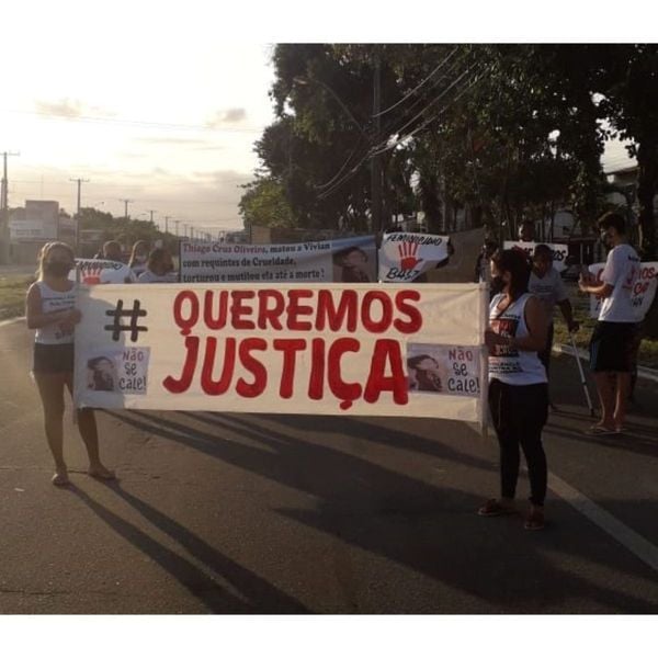 Manifestantes seguram uma faixa com os dizeres 