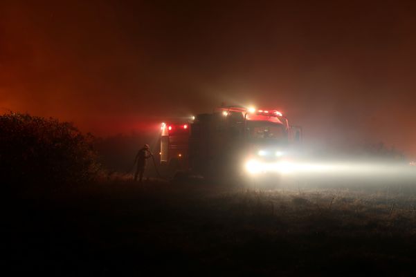 Bombeiro segura uma mangueira enquanto tenta apagar um incêndio em uma fazenda no Pantanal por Amanda Perobelli/REUTERS