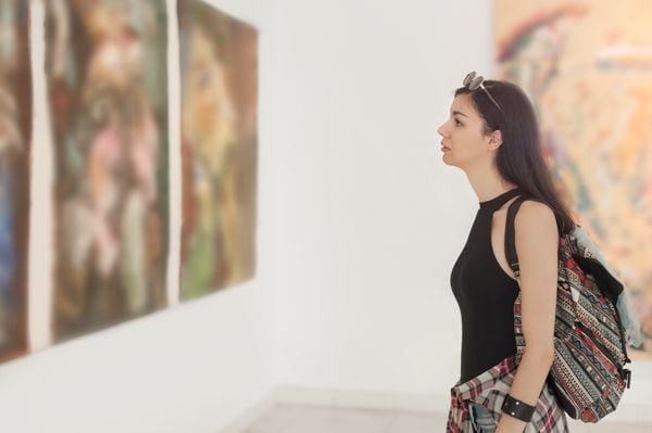 Mulher avaliando obra de arte em exposição