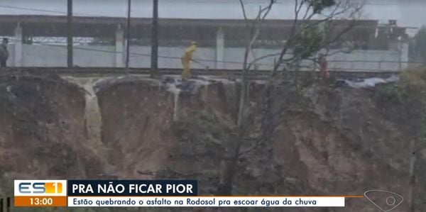 Homens quebram o asfalto na Rodovia do sol, em Ponta da Fruta, para escoar água da chuva