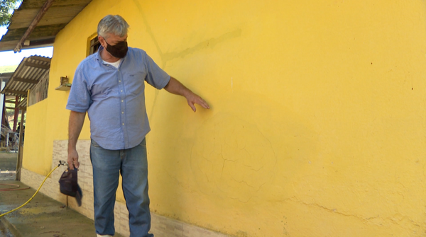 Produtor rural Ricardo Ferrone mostram parede que bandidos quebraram para furtar