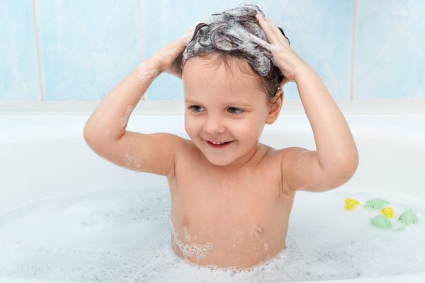 Criança (menino) no banho lavando o cabelo