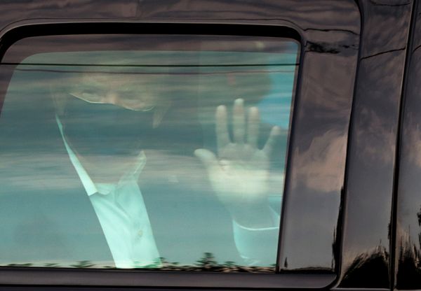 Presidente Donald Trump acena de dentro do carro para apoiadores nas proximidades do hospital Walter Reed, onde ele está internado