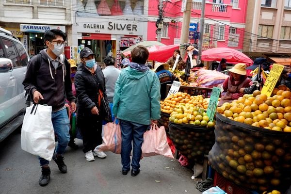 Bolivianos compram alimentos e carregam mantimentos no mercado Rodriguez, antes das eleições, em La Paz, Bolívia