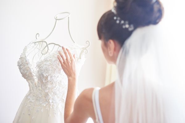 Mulher olhando para vestido de noiva