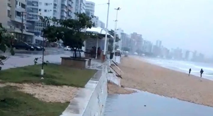 Nas imagens é possível ver uma grande quantidade de água suja jorrando do sistema de drenagem pluvial da orla direto na areia, formando uma mancha escura na praia