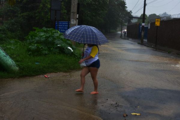 Moradora de Industrial, em Viana, atravessa poça formada pela chuva por Fernando Madeira