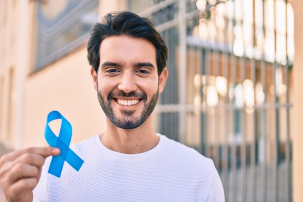Homem segurando o símbolo do Novembro azul, prevenção do câncer de próstata