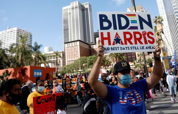 Pessoas reagem quando a mídia anuncia que o candidato democrata dos EUA à presidência, Joe Biden, venceu as eleições presidenciais de 2020 nos EUA, em Los Angeles