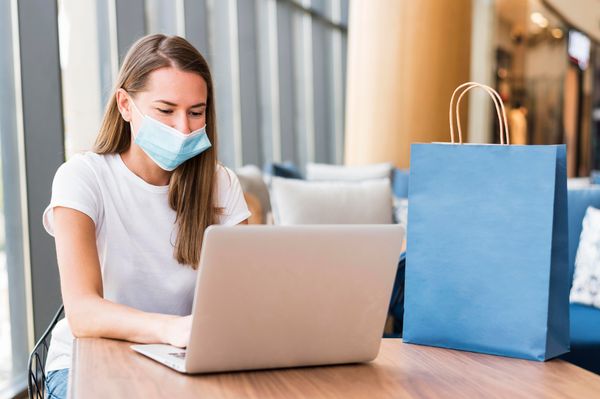 Mulher faz compras usando máscara