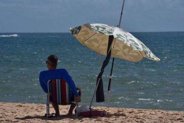 Homem pegando sol na Praia da Costa, em Vila Velha