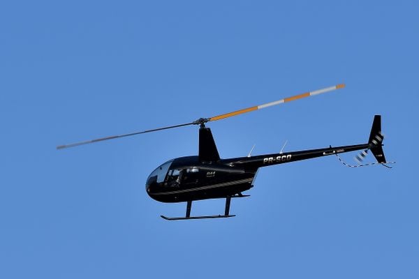 Helicóptero modelo R44 Raven II, semelhante ao que caiu, sobrevoa área do acidente - Helicóptero cai em área do Exército, em Riviera da Barra e mata o piloto e a namorada