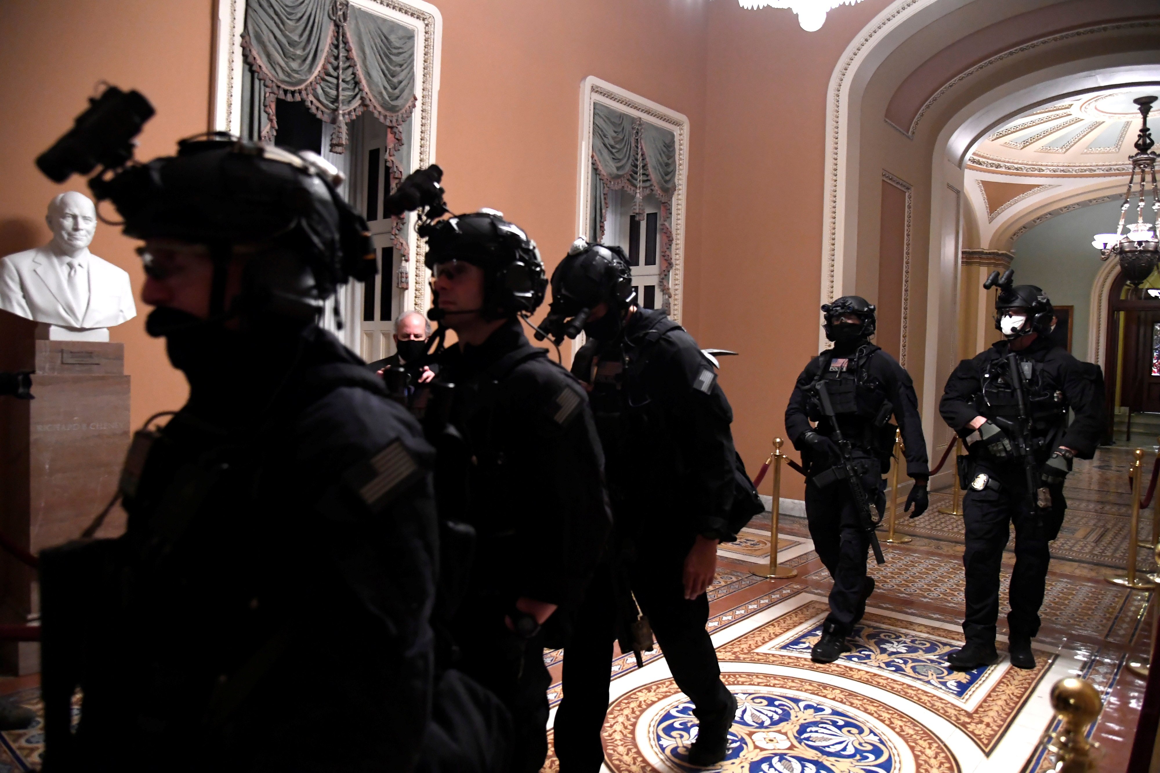 Black-clad security forces patrol the halls of the Senate in the U.S. Capitol, as a joint session continues to certify President-elect Joe Biden, in Washington, U.S., January 6, 2021. REUTERS/Mike Theiler ORG XMIT: PPP WAS71