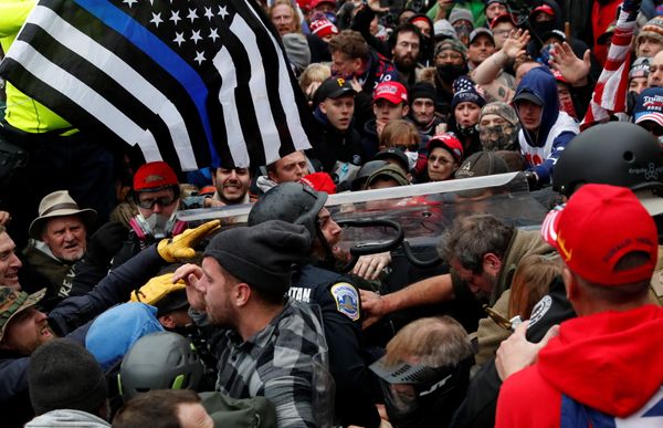 Um policial é arrastado em uma multidão de manifestantes pró-Trump durante um confronto por REUTERS/Shannon Stapleton/AP