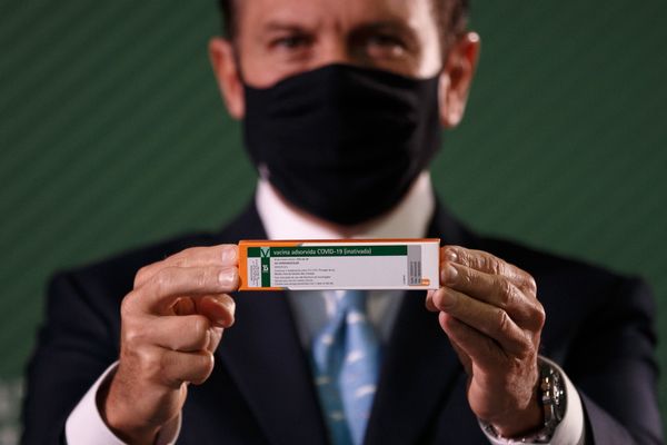 O governador de São Paulo, João Doria, segura caixa da vacina Coronavac durante coletiva de imprensa com informações sobre a vacina do Instituto Butantan contra a Covid-19