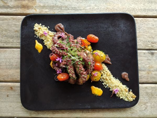 Polvo salteado, batatas ao murro, purê de cebola roxa, tomates confit e farofa de panko e castanha do restaurante Giardino, em Santa Teresa