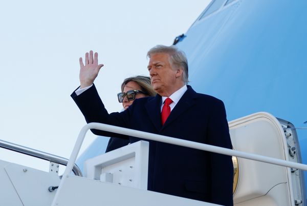 U.S. President Donald Trump, accompanied by first lady Melania Trump, waves as he boards Air Force One at Joint Base Andrews, Maryland, U.S., January 20, 2021. REUTERS/Carlos Barria ORG XMIT: GDN