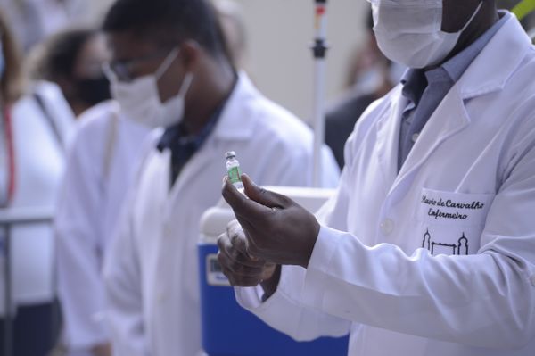 Servidor da Fiocruz prepara vacina de Oxford/AstraZeneca para a primeira aplicação no Brasil.