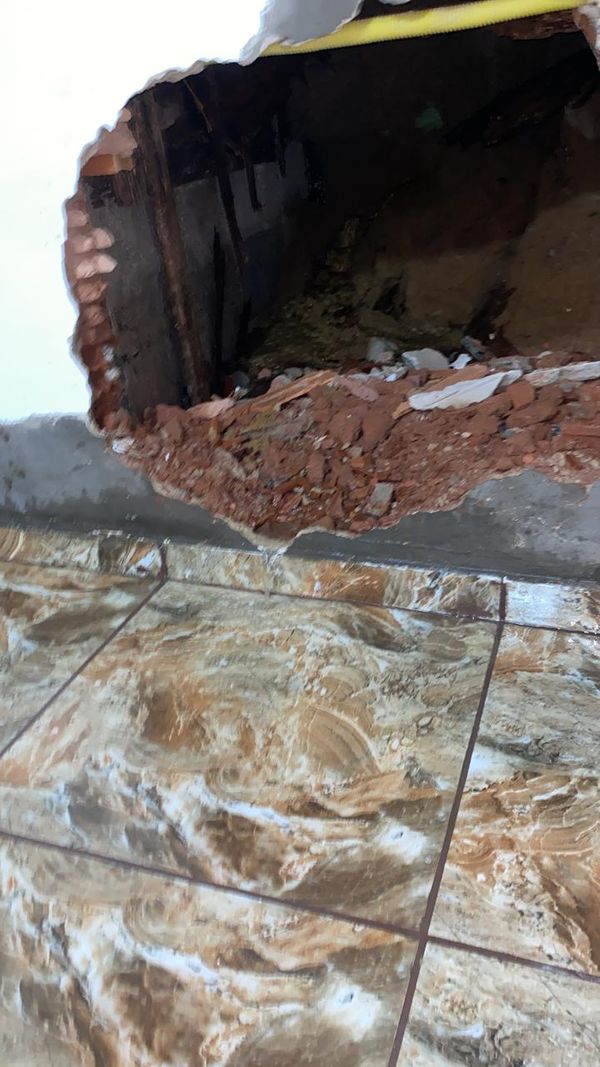 A irmã da Andréia chamou um pedreiro para averiguar o problema; por meio do buraco na parede ficou claro que água vinha de fora da residência por Andréia Nascimento da Silva