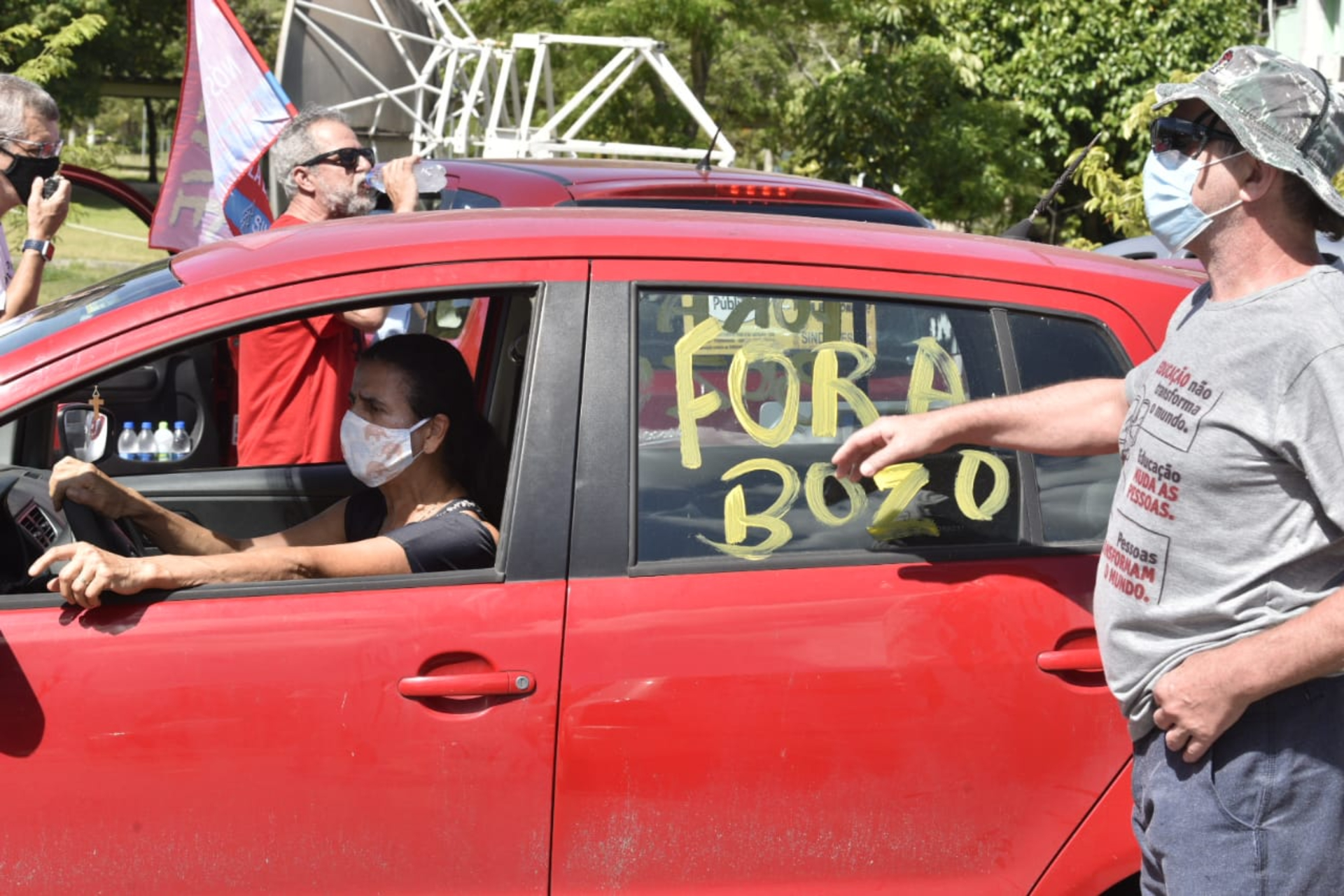 Manifestante pinta o vidro dos carros