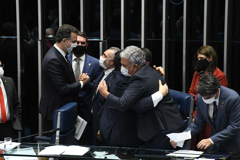 Senadores se cumprimentam com abraços durante a sessão